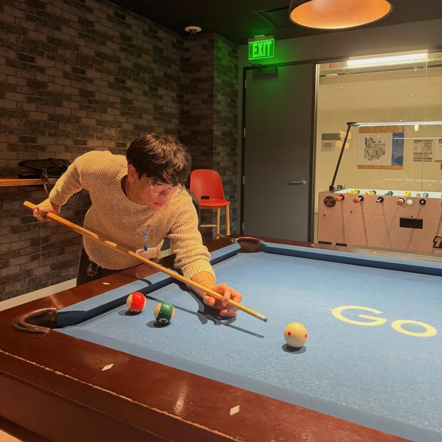 An officer plays pool on a Google-branded table
