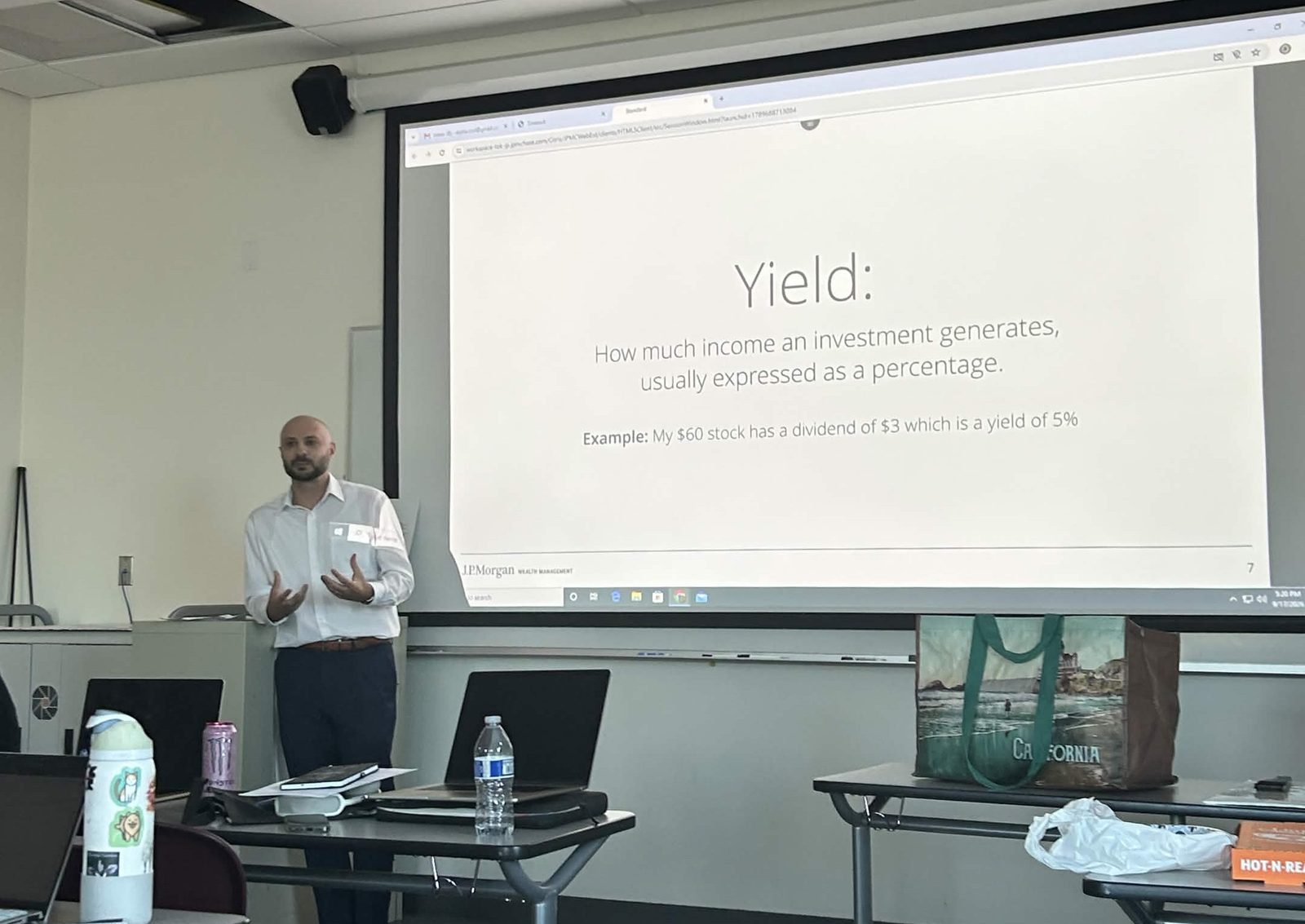 A speaker explains yield, with an example of a $60 stock paying a $3 dividend