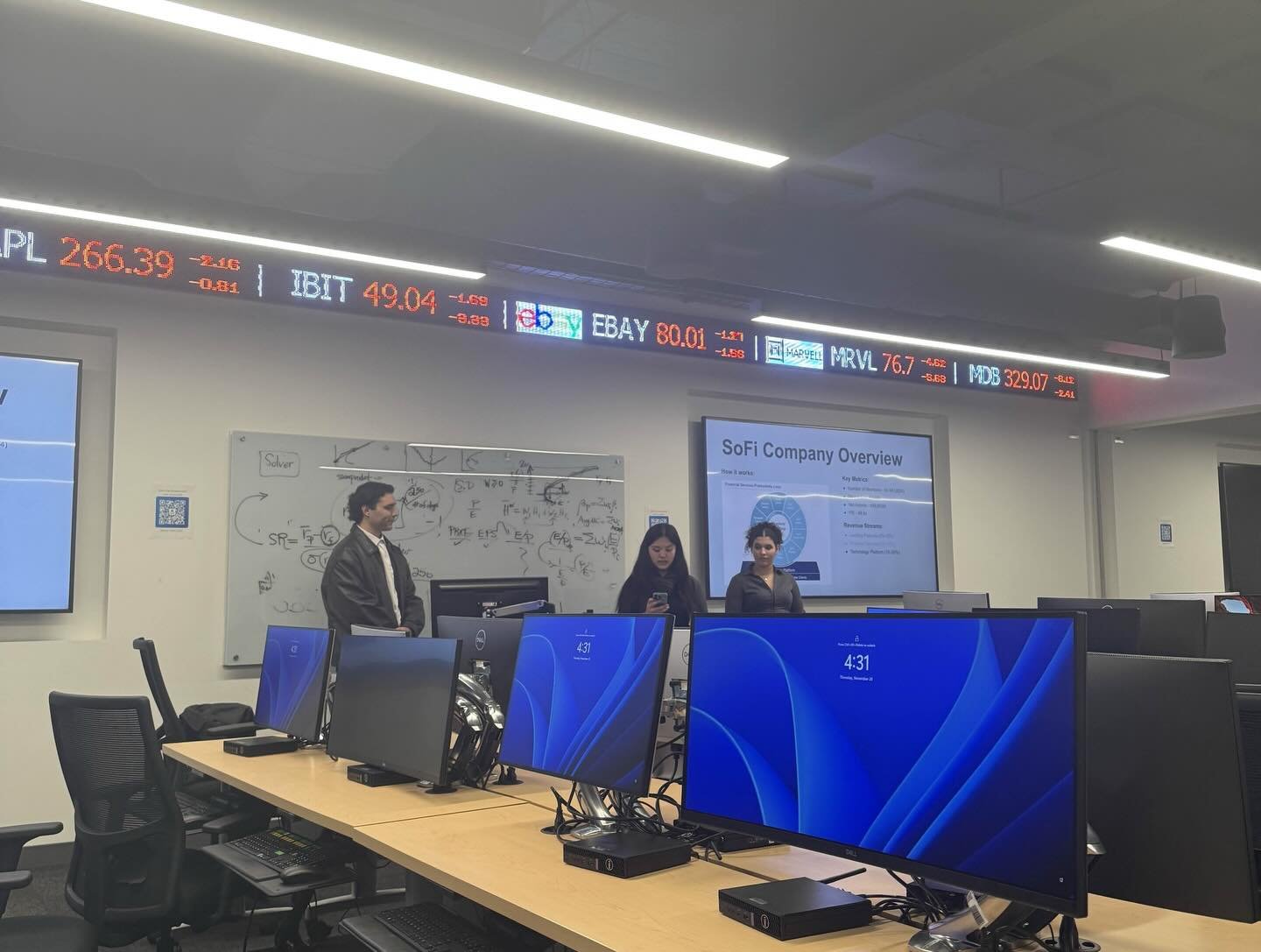 ABG's team presents a company overview in USF's investment lab, under a stock ticker